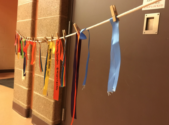 Ribbons displayed on a clothesline by attendees of Madison’s Wear Orange event for gun safety.