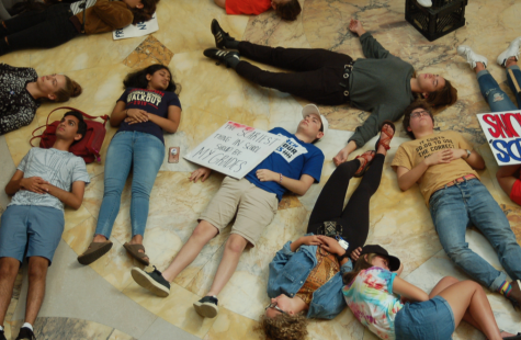 Students mimic being dead by laying on the floor