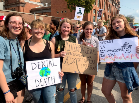 Five MHS students hold signs as the march from MG&E to the capitol begins. From left to right: Katie Frye (12), Indy Irwin (12), Celia Jones (12), Natasha Kinne (12), and Lane LaBoda (12). They shared their reasons for attending the climate strike. Frye mentioned that reports show we only have ten years to save the planet, so “I’m going to try to do as much as possible, as much as I can, to slow down the effects of climate change, and that includes encouraging my representatives to fight against it with renewable energy and other climate-friendly policies,” she said. LaBoda came because she believes in the power of the students, saying, “People underestimate the kids, but we have the most power of them all, so we got to be here to show off that power.” Jones stated her opinion succinctly: “We have one option left: destroy capitalism or destroy the world, and the choice is yours.”