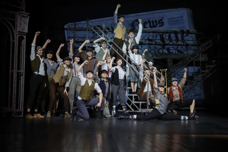 Members of the cast pose together on the spectacular Newsies set during dress rehearsals. They are in the spotlight and ready to give this show everything theyve got! From left to right: Kai DeRubis (12), Sarah Reichard (10), Vivian Szot (12), Sylvie Schmitz (9), Maddie Sorenson (11), Linus Ballard (9), Owen Sehgal (9), Elora Doxtater (12), Kennedy Wagner (11), Annabelle Latino (11), Alex Arinkin (11), Matthew Jordan (11), Benny Greenberg (4), Tanner Choate (12), Miriam Smith (9), Annie Leffel (12), and Vera Akimova (11).