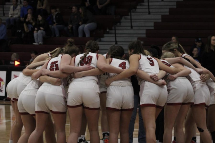 The+girls+team+gathers+in+a+huddle+on+the+court+before+their+game.+Girls+varsity+basketball+went+13-11+in+their+2022-2023+season+under+new+head+coach+Rashard+Griffith.