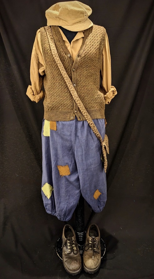Jack, a daring young boy, was played by MHS sophomore Owen Sehgal. He is responsible for climbing the overgrown beanstalk and angering the giants in the sky by stealing their gold. He only wants to help his mother, who complains of having no money but inadvertently gets himself and the rest of the kingdom into trouble. His costume, fit for his risky stunts in the sky, consists of a caramel-colored button-up, brown vest and blue knee-length pants. He carries a satchel to bring stolen goods from the giant’s territory back to his mother.