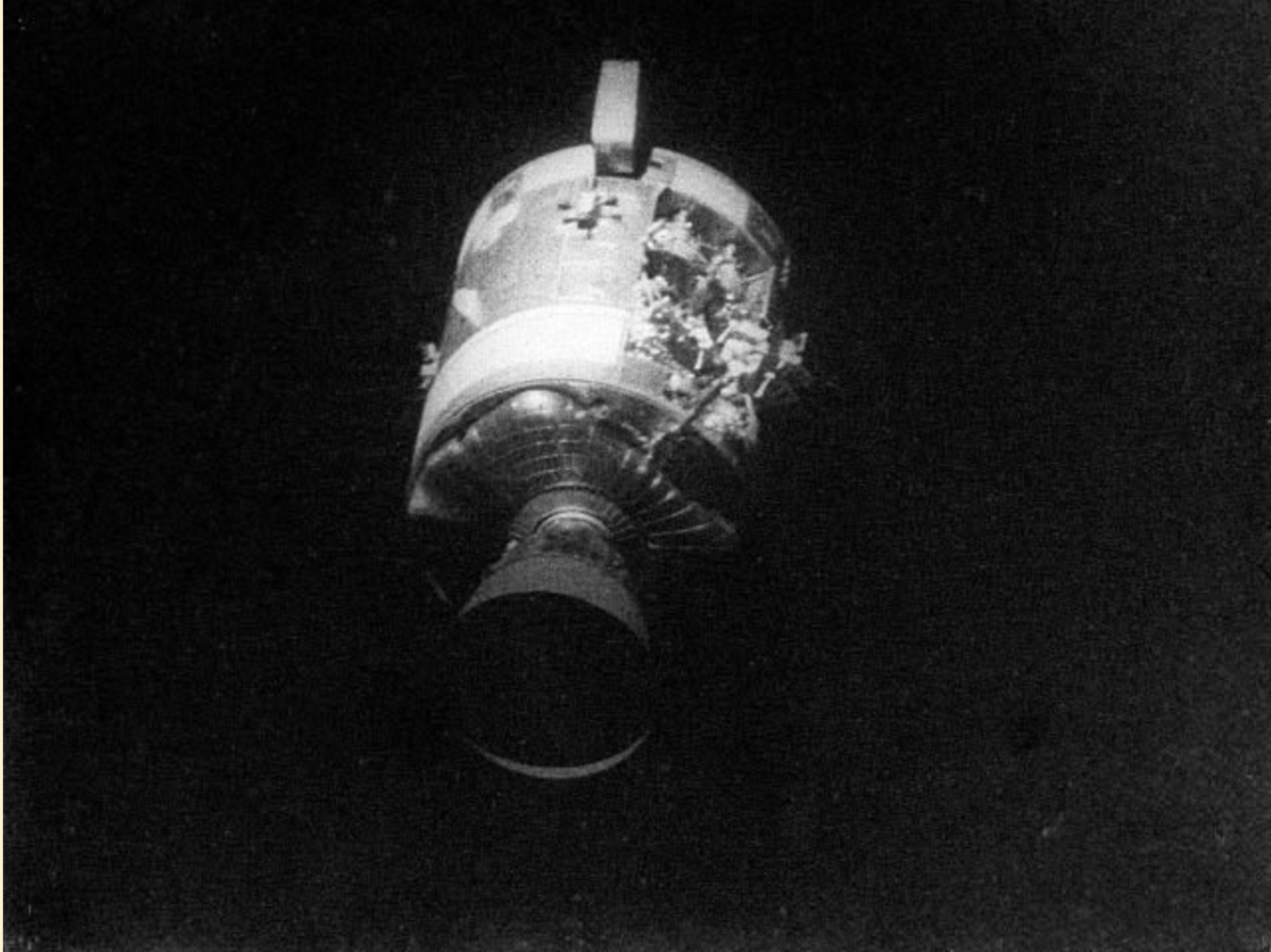 The service module of the Apollo 13 spacecraft, missing a panel from the oxygen explosion, drifts off into space after abandoned by the crew, four hours before returning to Earth.