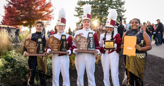 The Middleton High School drum majors  and color guard captions holding the state championship awards.