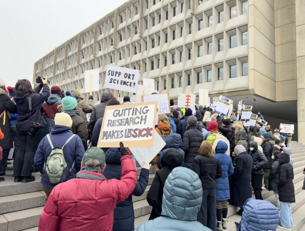 Protesters gather in front of the US Department of Health and Human Services headquarters.