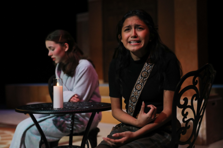 Antigone (Ailin Sanchez) and Ismene (Lila Elliot) sit together during an emotionally charged scene after the death of their brothers.
