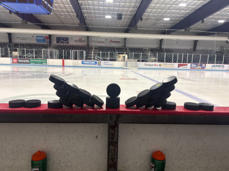 A photo of a hockey puck tower, assembled for each game.